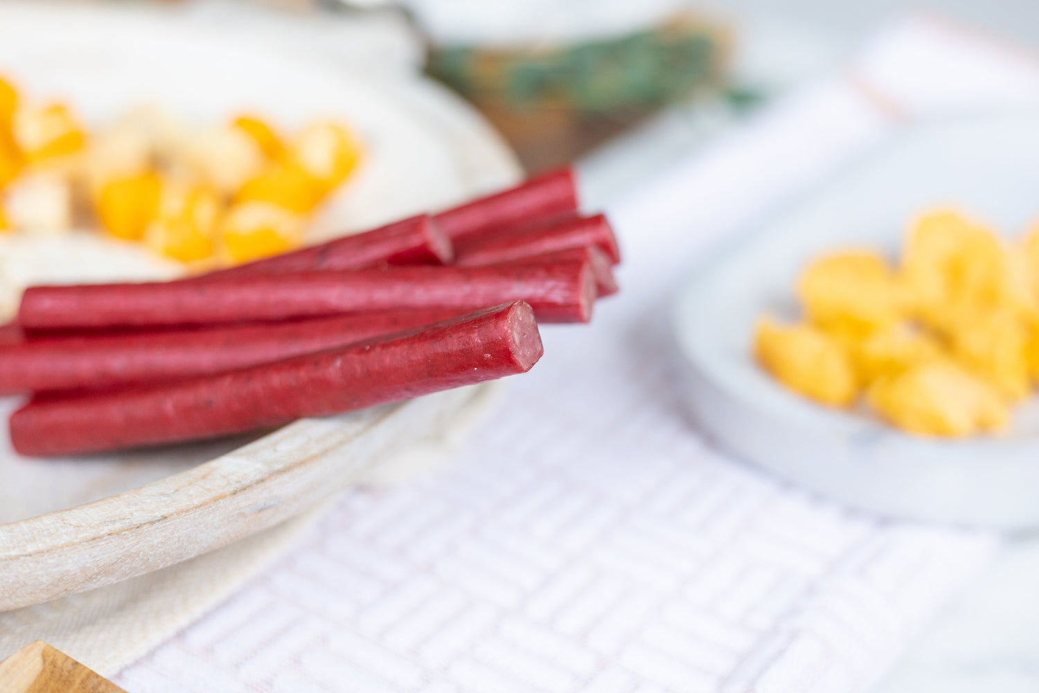 Meat snacks on a place, including: summer sausage, beef sticks and beef jerky